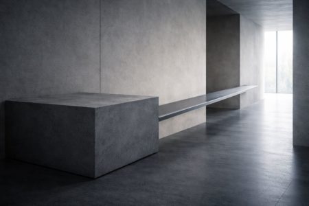 Bloque de hormigón y pasarela metálica en un interior minimalista como metáfora de base sólida y exploración controlada